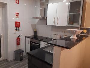 a kitchen with white cabinets and a black counter top at Villa Sofia in Foz do Arelho