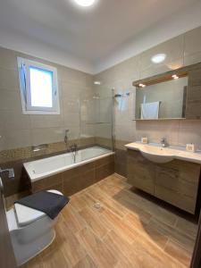 y baño con bañera, aseo y lavamanos. en Tasos Cozy House, en Lefkada
