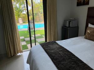 a bedroom with a bed and a view of a pool at Oyster Guest House in Durban