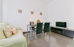 sala de estar con sofá, mesa y TV en Nice Home In El Coronil With Kitchenette, en El Coronil