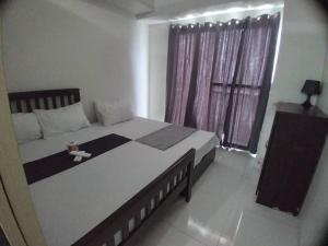 Un dormitorio con una cama grande y una ventana en Wind Residence T4- I Near TAAL VIEW at sky lounge, en Nasugbu