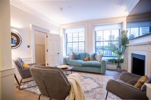 een woonkamer met een bank en een open haard bij Liverpool St Three Bedroom Home near Tube Station in Londen