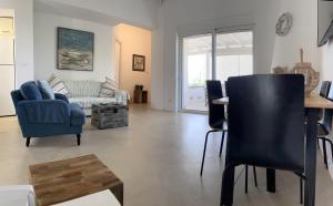 a living room with blue chairs and a table at Bay View Villas in Methoni
