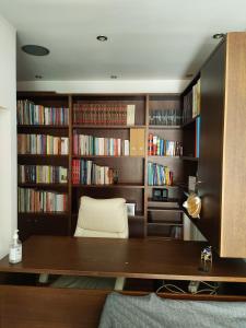 a room with a desk and book shelves with books at MUSEUM apartment in Volos
