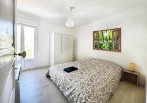een slaapkamer met een bed en een foto aan de muur bij Charmant T3 en plein centre du Bousquet-d'Orb in Le Bousquet-dʼOrb