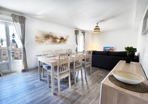 een woonkamer met een tafel en stoelen en een bank bij Charmant T3 en plein centre du Bousquet-d'Orb in Le Bousquet-dʼOrb