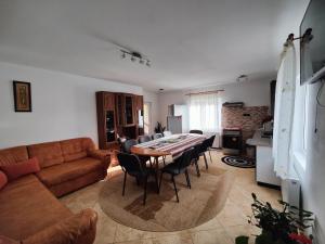 sala de estar con sofá, mesa y sillas en Casa Poiana Teiului, en Poiana Teiului