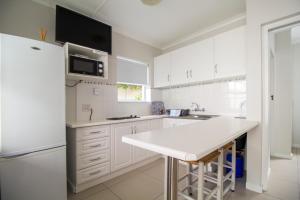 a kitchen with white cabinets and a white counter top at South Point Guest Lodge in Agulhas