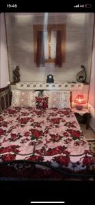 a bedroom with a large bed with a floral blanket at Η θεα traditional house in Makrinítsa