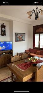 salon ze stołem i telewizorem w obiekcie Η θεα traditional house w mieście Makrinítsa