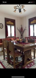 a dining room with a wooden table and chairs at Η θεα traditional house in Makrinítsa