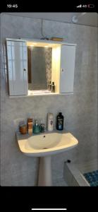 W łazience znajduje się biała umywalka i lustro. w obiekcie Η θεα traditional house w mieście Makrinítsa