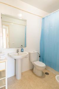 W łazience znajduje się umywalka, toaleta i lustro. w obiekcie BLUE Home w mieście Puertito de Güímar