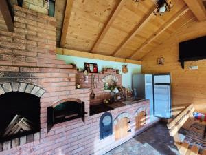 a kitchen with a brick fireplace in a house at Casa Poiana Teiului in Poiana Teiului