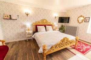 ein Schlafzimmer mit einem goldenen Bett und einem roten Sofa in der Unterkunft Private & Comfortable Apartments in Puttelange-aux-Lacs