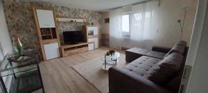a living room with a couch and a television at Ferienwohnung am Brohlbach in Gamlen