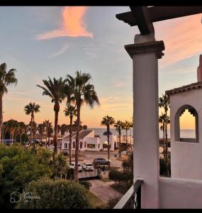 een balkon met uitzicht op een resort met palmbomen bij Apartamento Zahara de los Atunes-Atlanterra in Zahara de los Atunes