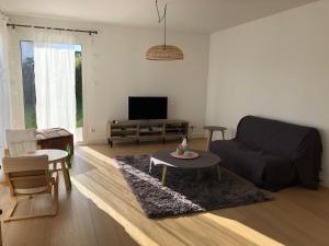 a living room with a couch and a table at Charmante maison à proximité de Bordeaux in Gradignan