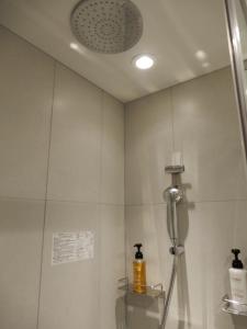 a shower in a bathroom with a shower head at Smile Hotel Hiroshima in Hiroshima