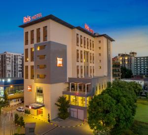 un bâtiment d'hôtel avec un panneau en haut dans l'établissement ibis Adana, à Adana