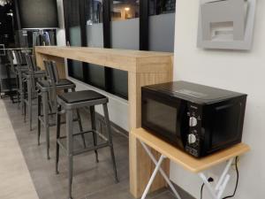 a bar with a microwave on a table with stools at Smile Hotel Hiroshima in Hiroshima