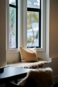una almohada sentada en un asiento junto a la ventana en una habitación en Laneway Apartments, en Napier