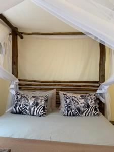1 cama con almohadas de cebra en una habitación en iMbamuweti Cottage, en Grietjie Game Reserve