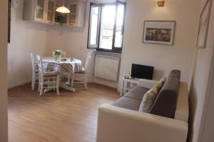 ein Wohnzimmer mit einem Sofa und einem Tisch in der Unterkunft San Bartolomeo Apartment in Pistoia