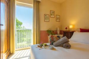 a bedroom with a bed and a large window at Fattoria di Magliano Winery in Magliano in Toscana