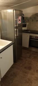 a kitchen with a stainless steel refrigerator with a sticker on it at Location RDC logement T2 meublé in Saint-Avit-Saint-Nazaire