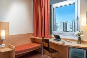 Cette chambre comprend un bureau avec un ordinateur portable et une fenêtre. dans l'établissement ibis Adana, à Adana