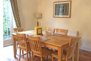 uma sala de jantar com uma mesa de madeira e cadeiras em Courtyard Holiday Cottage No 8 em Bettystown