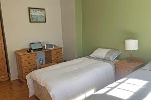 1 Schlafzimmer mit 2 Betten und einem Schreibtisch mit einem Laptop in der Unterkunft Courtyard Holiday Cottage No 8 in Bettystown