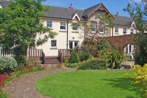 uma casa com um jardim em frente em Courtyard Holiday Cottage No 8 em Bettystown