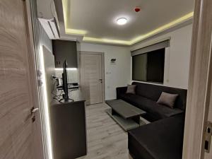 a living room with a black couch and a television at 43m luxury room near downtown and all services in Amman