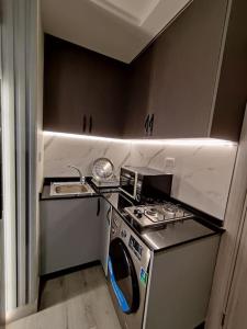 uma pequena cozinha com um fogão e um lavatório em 43m luxury room near downtown and all services em Amã