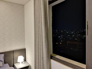 a bedroom with a large window with a city view at 43m luxury room near downtown and all services in Amman