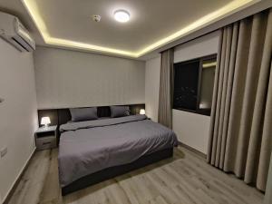sypialnia z dużym łóżkiem i oknem w obiekcie 43m luxury room near downtown and all services w mieście Amman