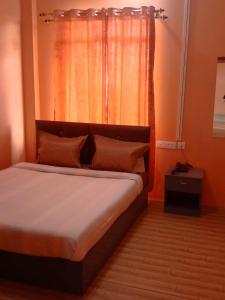 een slaapkamer met een groot bed en een raam bij Picture Perfect Homestay in Cherrapunji