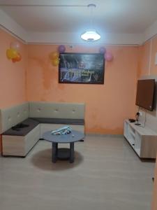 een kamer met een bank, een tafel en ballonnen bij Picture Perfect Homestay in Cherrapunji