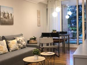 布爾戈斯的住宿－Alojamientos Castellana Jardín 1 y 2 PARKING Y PISCINA GRATIS!!，客厅配有沙发和桌子