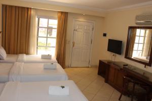 una camera d'albergo con due letti e una televisione di Herrmes Hospitality a Sharm El Sheikh