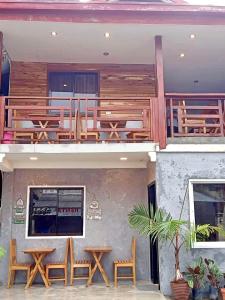 a restaurant with wooden tables and chairs on a building at RL Harbor Inn in El Nido