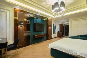 um quarto com uma cama e uma televisão de ecrã plano em East Star Hotel em Samarcanda