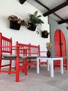 a room with two benches and a table with a potted plant at Apartamento “Las Cuadras “ in Cádiz