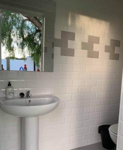 W łazience znajduje się biała umywalka i lustro. w obiekcie Apartamento “Las Cuadras “ w Kadyksie