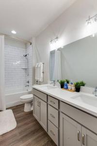 a bathroom with two sinks and a toilet and a mirror at #BestStayEverNashville in Nashville