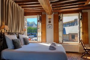 a bedroom with a large bed and a large window at Chambres Houdaille in Honfleur