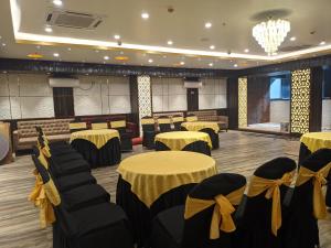 a banquet hall with tables and chairs with yellow bows at Hotel Aavas Inn in Tezpur