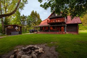 a house with a red roof and a yard at Chata Smiech in Ružomberok